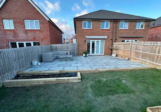 Patio lifted, relaid in Indian sandstone, sleeper flowerbed added.