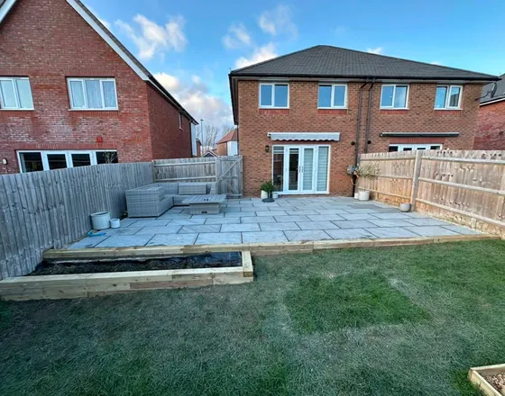Patio lifted, relaid in Indian sandstone, sleeper flowerbed added.