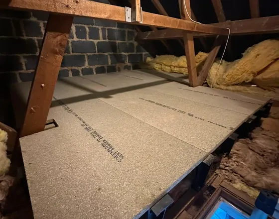 A loft boarded out on raised legs over new insulation.